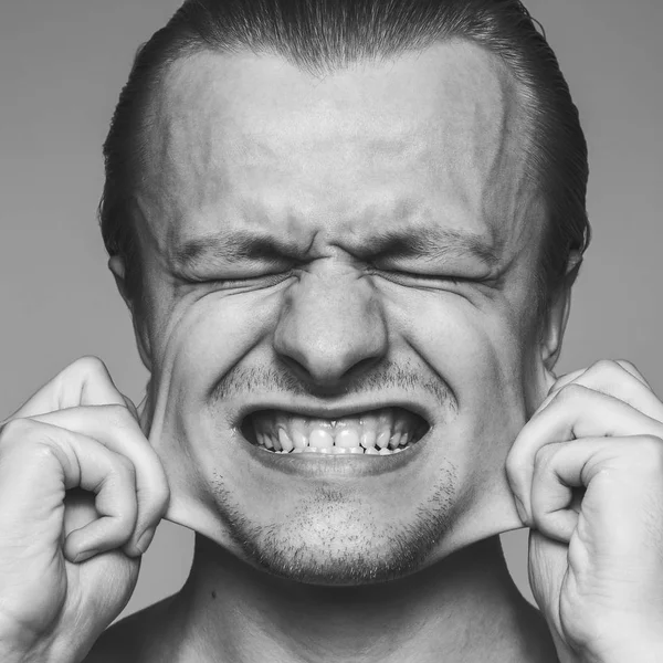 Man stretching out his cheeks — Stock Photo, Image