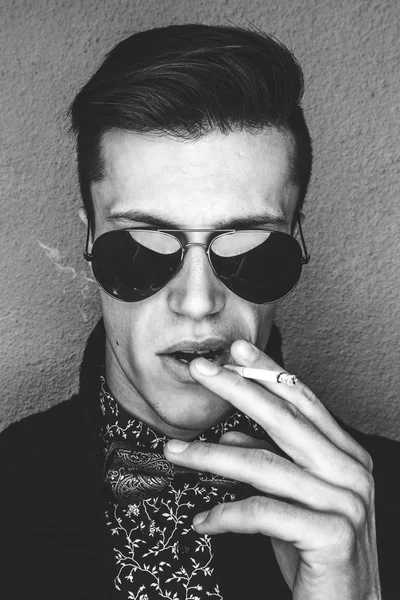 Людина в сонцезахисних окулярах курить цигарку — стокове фото
