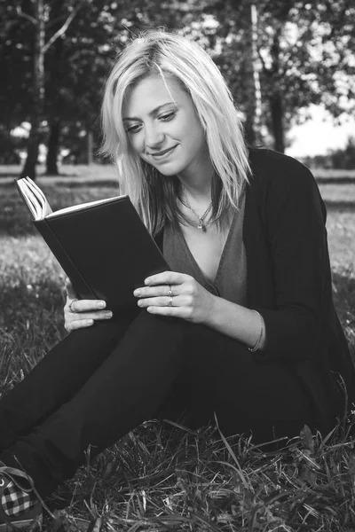 Estudiante chica leyendo libro sobre hierba — Foto de Stock