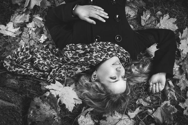 Girl in scarf lying under autumn tree — Stock Photo, Image