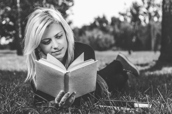 公園の芝生の上を読んでいる女の子 — ストック写真