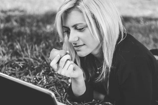 Student meisje met laptop studeren in park — Stockfoto