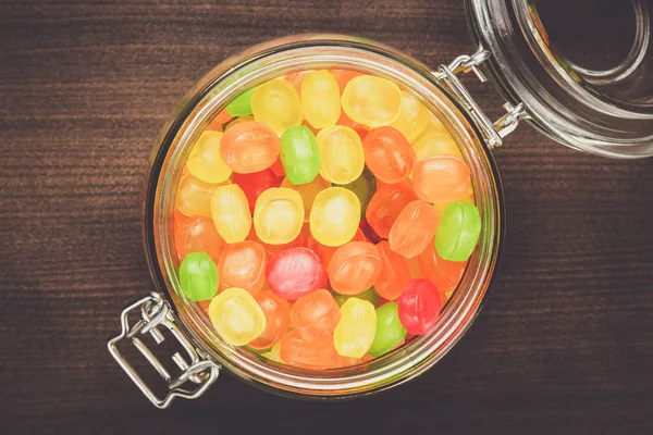 Glass jar full of colorful sweets — Stock Photo, Image