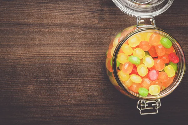 Tarro de vidrio lleno de dulces de colores — Foto de Stock