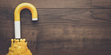 Masanın üzerinde katlanmış sarı şemsiye