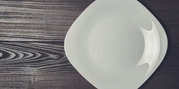 Quadratischer Teller auf dem braunen Holztisch — Stockfoto