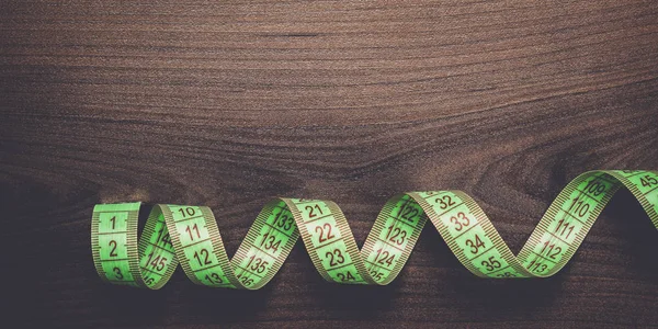 Yeşil bant kahverengi ahşap zemin üzerinde ölçüm — Stok fotoğraf