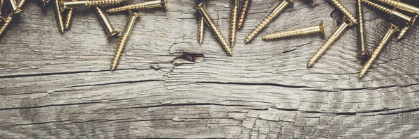 Yellow screws on the wooden table — Stock Photo, Image