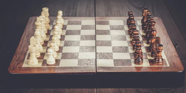 Chess board with figures on wooden table — Stock Photo, Image