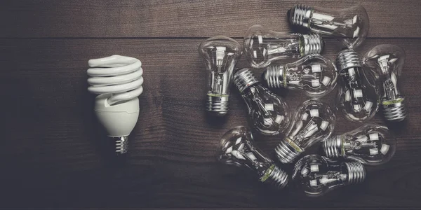 Bulb uniqueness concept on the wooden table — Stock Photo, Image