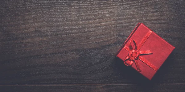 木製の背景に赤のプレゼント ボックス — ストック写真