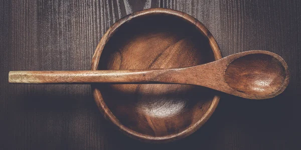 Holzsalatteller und Löffel auf braunem Tisch — Stockfoto