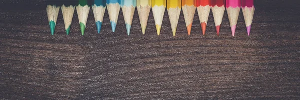Kahverengi ahşap masa üzerinde çok renkli kalemler — Stok fotoğraf