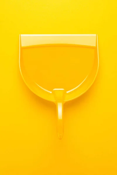 A sárga háttér műanyag szemétlapát — Stock Fotó