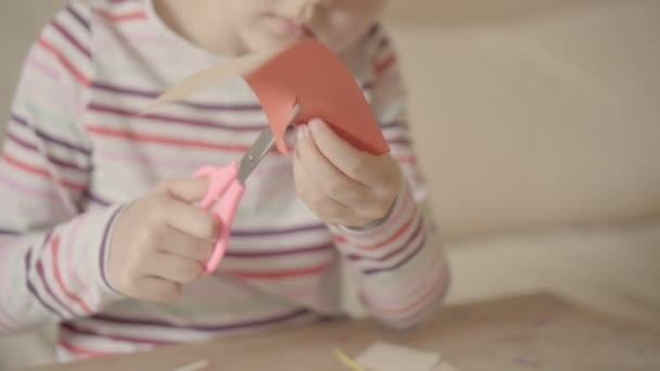 Mädchen schneidet verschiedene Papierformen aus — Stockvideo