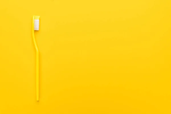 Plastic toothbrush on yellow background — Stock Photo, Image