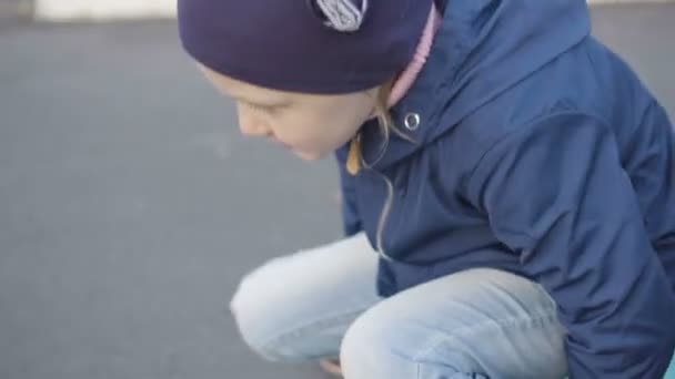 Girl sitting on mini cruiser board — Stock Video