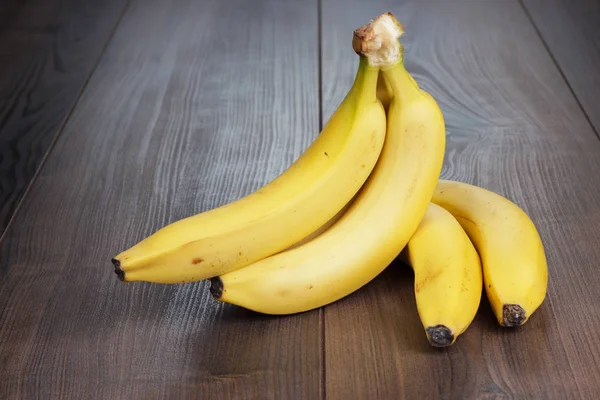 Свежие бананы на коричневом столе — стоковое фото