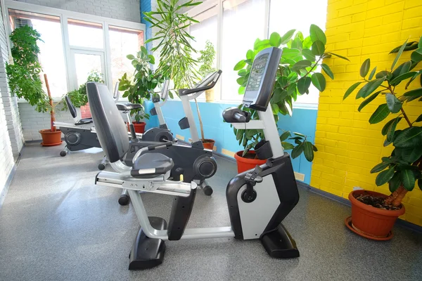 Salão de fitness com bicicleta esportiva — Fotografia de Stock