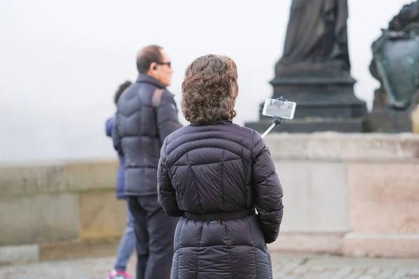 Turistická umožňuje fotografii na Karlově mostě v Praze — Stock fotografie