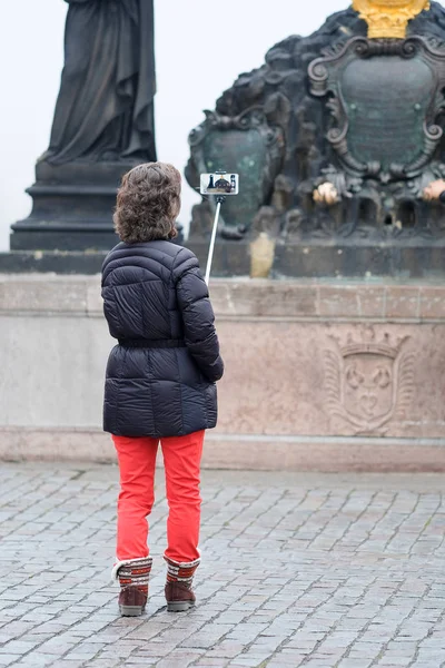 Turistická umožňuje fotografii na Karlově mostě v Praze — Stock fotografie