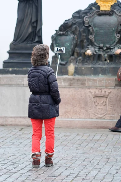Turistická umožňuje fotografii na Karlově mostě v Praze — Stock fotografie