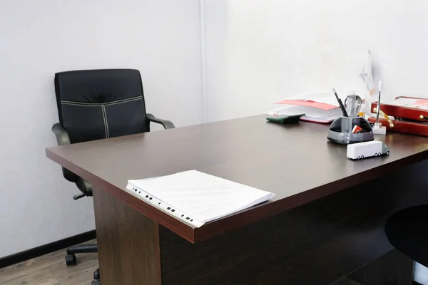 Salle de bureau avec chaise, table et papeterie dessus — Photo