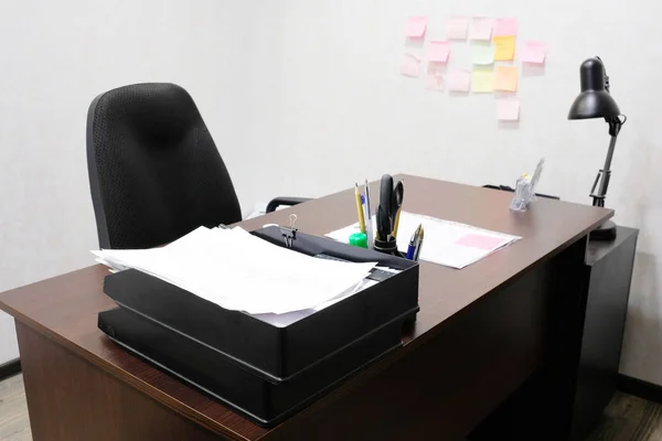 Une salle de bureau avec chaise, table, lampe et papeterie dessus — Photo