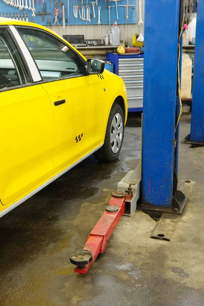 Κίτρινο ταξί υπό επισκευή σε ένα σταθμό επισκευής αυτοκινήτων — Φωτογραφία Αρχείου