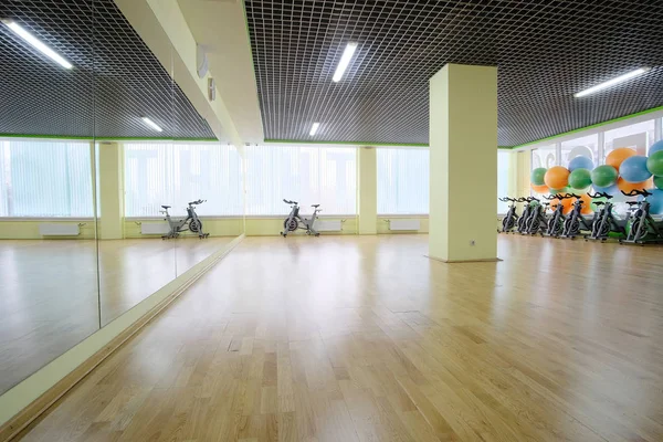Salão de fitness com as bicicletas esportivas nele — Fotografia de Stock