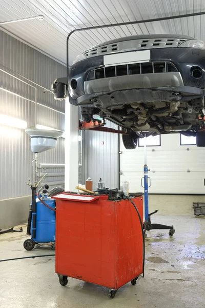 Car on a lift in a car repair station — Stock Photo, Image