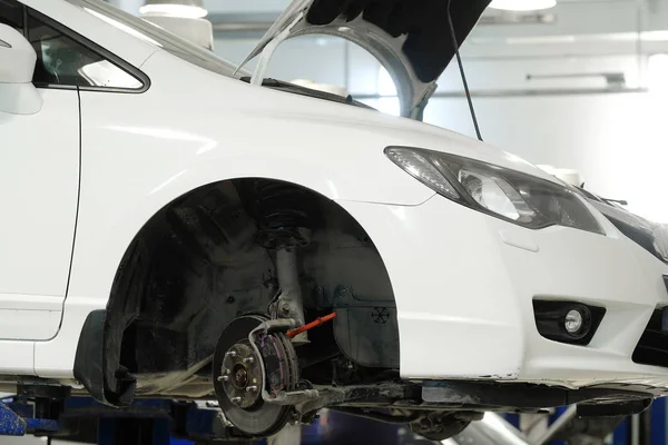 Car on a lift in a car repair station — Stock Photo, Image