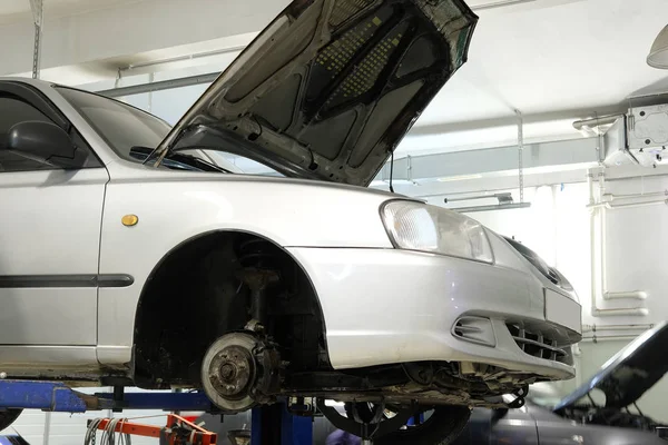 Voiture sur un ascenseur dans une station de réparation automobile — Photo