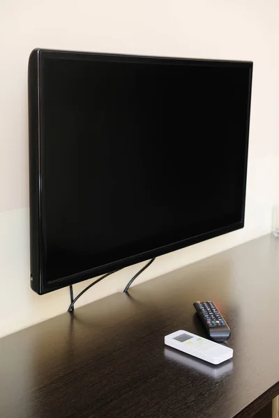 TV en de afstandsbediening op de tafel — Stockfoto