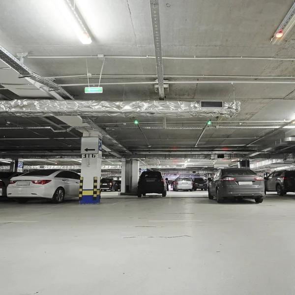 Voitures sur un parking sous le toit dans un centre d'exposition Crocus à Moscou — Photo