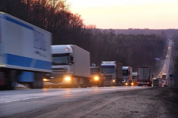 Vrachtwagens op een snelweg in een avond — Stockfoto