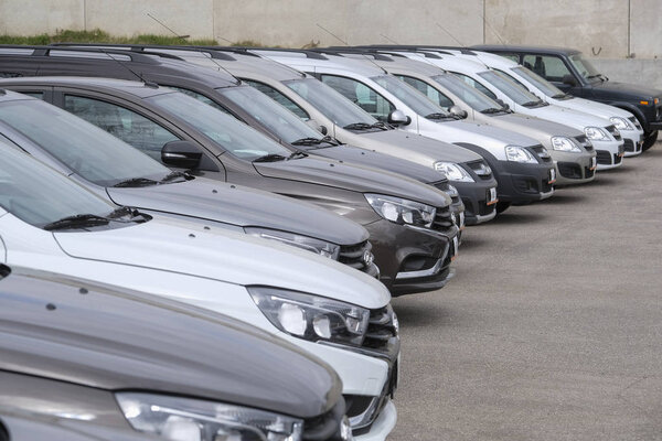 Новые автомобили на парковке в автосалоне

