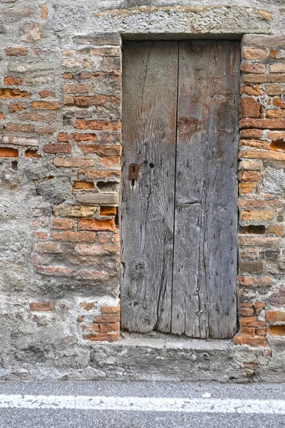 Porta de madeira antiga em uma parede de tijolo — Fotografia de Stock