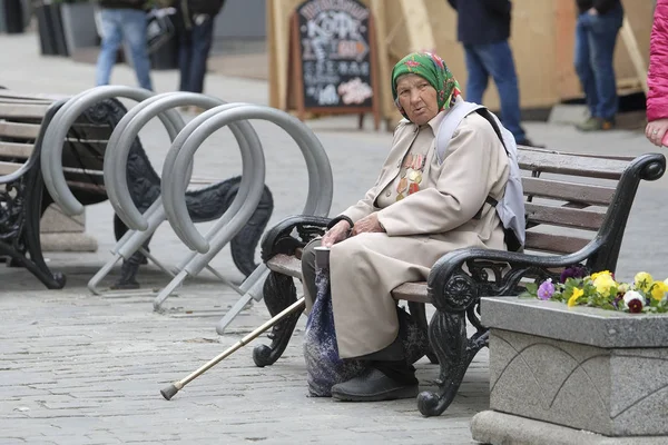 An elderly woman veteran of the 2 World War begs in Moscow on the eve of the magnificently celebrated Victory Day in this war — Stock Photo, Image