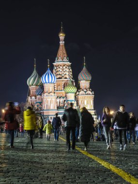 Moskova, Rusya - 28 Ekim 2019: Kızıl Meydan 'da gece boyunca St. Mary' nin arka planında yürüyen turist görüntüsü Moskova 'daki Basil Katedrali