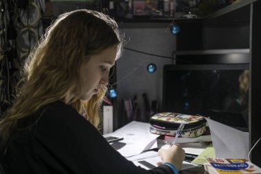 Akşamları okul ödevi yapan bir kızın görüntüsü
