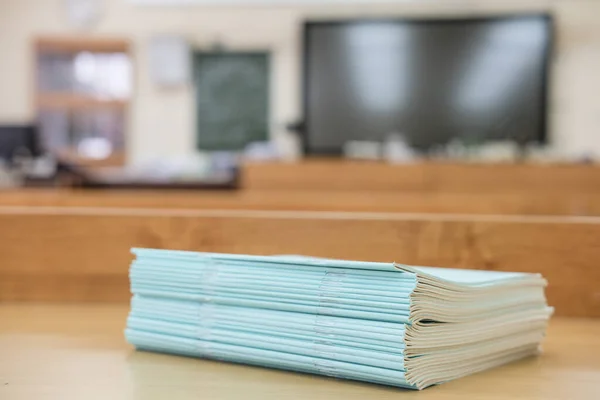 image of a stack of notebooks on a school desk