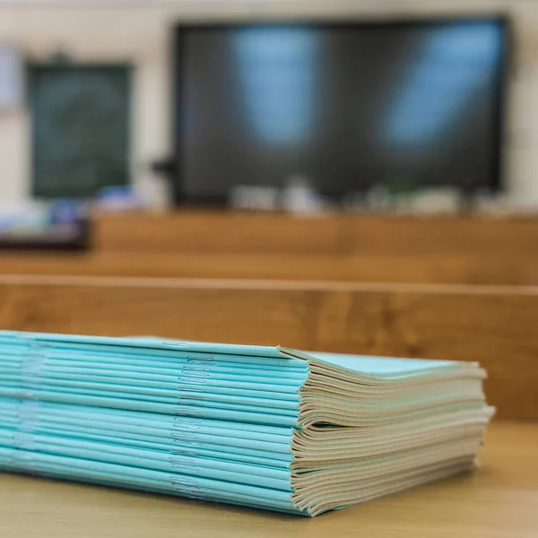 image of a stack of notebooks on a school desk