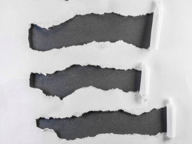 Siyah arkaplan üzerindeki yırtık kağıt şeritlerinin resmi