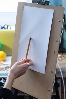 Resim sehpasında resim yapan bir kız resmi