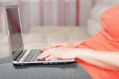 Kadın evde defterle çalışıyor.