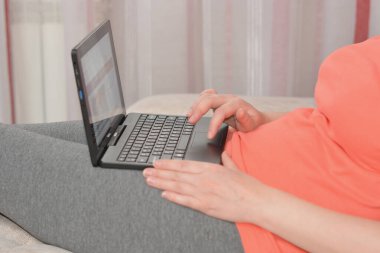 Kadın evde defterle çalışıyor.