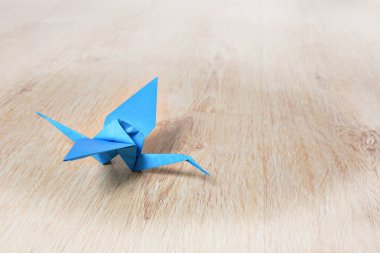 Oak ahşap zeminde mavi origami vinç