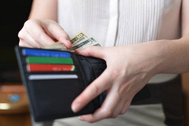 Elinde para olan siyah bir çanta.