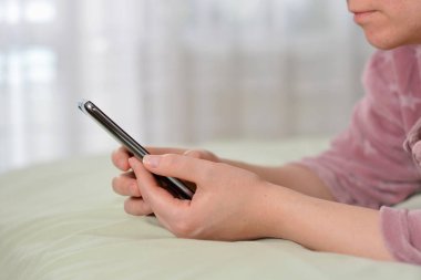 Sabahları evde cep telefonu kullanan rahat bir kadın.